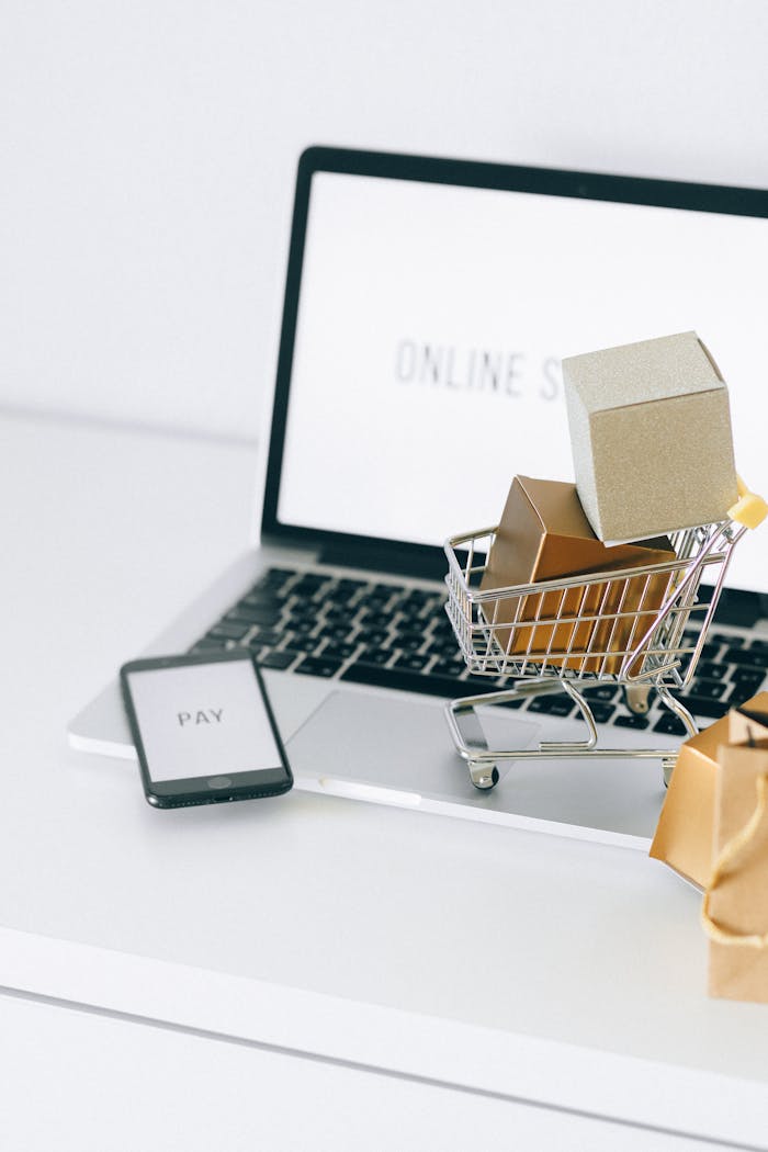 hero-img-02 Mini shopping cart on laptop symbolizing online shopping and e-commerce transactions.